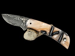 #717 - Nolen small drop point.  Blade 2 3/4, overall 6 1/2.  Made with Damascus.  The handle material is oyster pearl acrylic.  $200.00